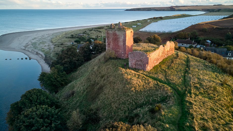 Stunning aerial view of Red Castle overlooking Lunan Bay in Angus, Scotland. Perfect travel destination for history lovers.