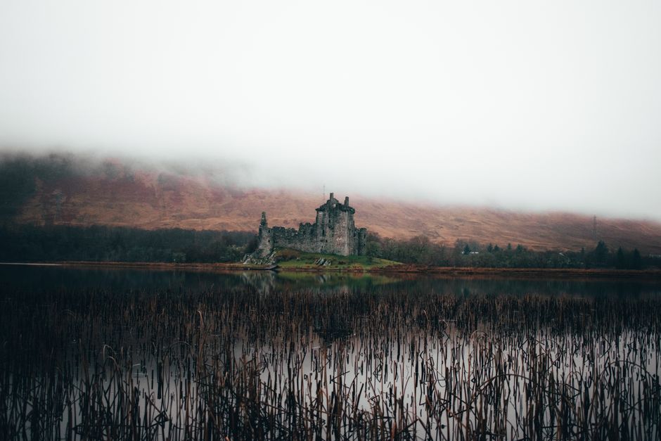 Atmospheric image of Kilchurn Castle shrouded in fog on Loch Awe, Scotland.